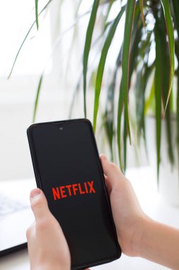 Prag, Çek Cumhuriyeti - 26 Ocak 2025: Netflix logosunu kapalı alanda bir kullanıcı tarafından tutulan ekranda gösteren akıllı telefon. Canlı eğlence konsepti. Yüksek kaliteli fotoğraf..