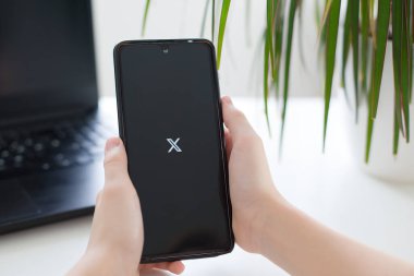 Prag, Çek Cumhuriyeti - 30 Ocak 2025: Sosyal medya kullanımını temsil eden Twitter logosunu ekranda gösteren kişinin elinde bulunan bir akıllı telefon. Yüksek kaliteli fotoğraf..