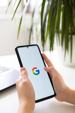 Prag, Çek Cumhuriyeti - 30 Ocak 2025: Google logosunu ekranda gösteren ve internet arama ve arama motoru hizmetlerini sembolize eden bir kişinin elinde bulunan akıllı telefon. Yüksek kaliteli fotoğraf..