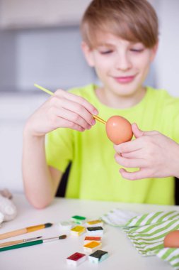Paskalya yumurtalarını süsleyen yaratıcı bir tatil geleneğinin tadını çıkaran bir çocuk. Mevsimlik el sanatları, DIY ve festival aktiviteleri kavramı. Yüksek kaliteli fotoğraf..