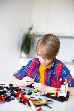 Meraklı bir çocuk yerde renkli yapı taşlarıyla oynuyor. Oyun, gelişme ve yaratıcılık yoluyla öğrenme kavramı. Yüksek kaliteli fotoğraf..