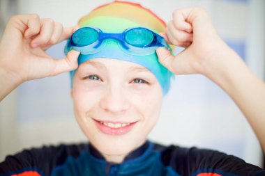 Yüzme kıyafeti giymiş, eğitime hazır bir çocuk. Spor anlayışı, adanmışlık ve çocukların fiziksel gelişimi. Yüksek kaliteli fotoğraf..