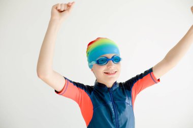 Gülümseyen genç bir yüzücü çocuk spordaki başarıyı ve zaferi simgeliyor. Çocuk yarışmaları, başarı ve motivasyon kavramı. Yüksek kaliteli fotoğraf..