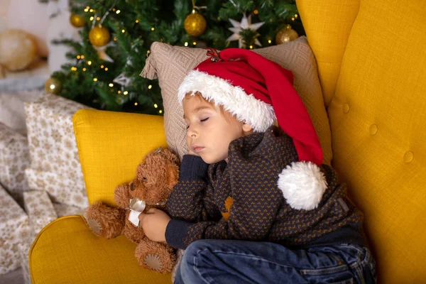 Sevimli çocuk, çocuk, sarı koltukta uyuyor Noel için süslü bir odada, rahat bir yerde.