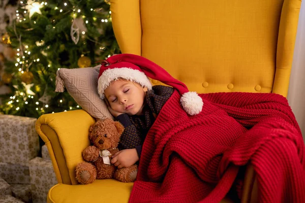 Sevimli çocuk, çocuk, sarı koltukta uyuyor Noel için süslü bir odada, rahat bir yerde.