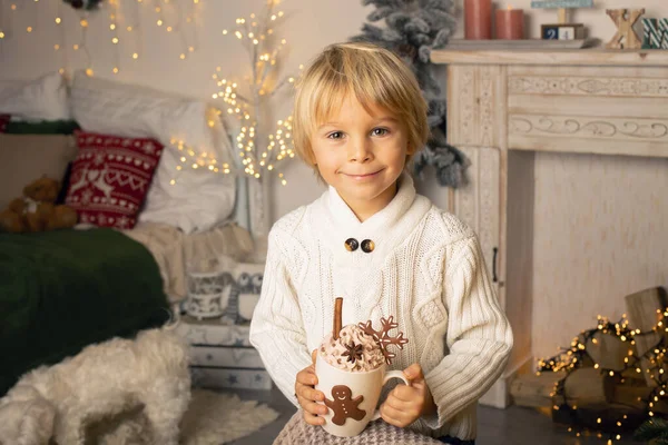 Tatlı çocuk, oğlum, Noel için süslü bir odada sarı bir koltukta oturuyor, rahat bir yer.