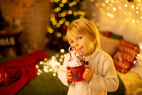 Tatlı çocuk, oğlum, Noel için süslü bir odada sarı bir koltukta oturuyor, rahat bir yer.