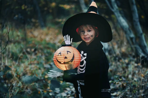 ハロウィーンの衣装を着た就学前の子供と帽子をかぶった森の中のジャック ランタン 怖いスケルトン — ストック写真