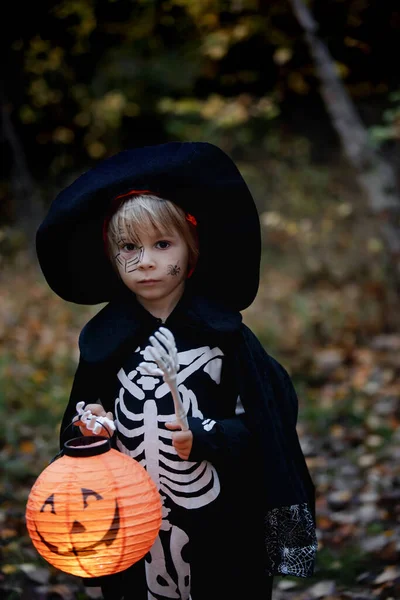 ハロウィーンの衣装を着た就学前の子供と帽子をかぶった森の中のジャック ランタン 怖いスケルトン — ストック写真