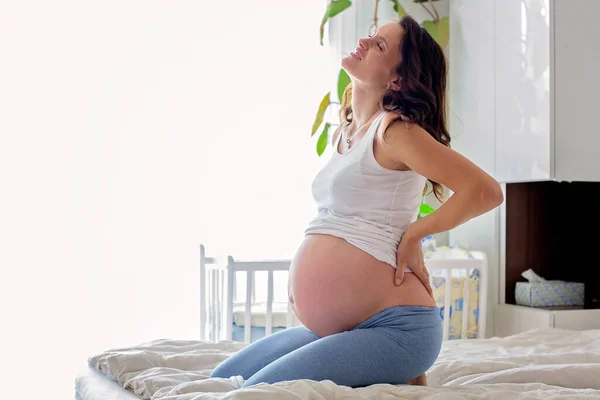 Młoda Piękna Kobieta Ciąży Cierpiąca Skurcz Porodowy Siedząca Łóżku Sypialni — Zdjęcie stockowe
