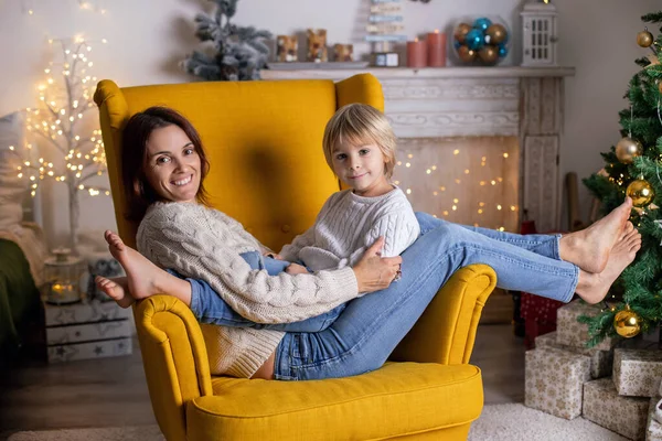 かわいい子供 母と祖母とクリスマスのための装飾された部屋に黄色のアームチェアに座って — ストック写真