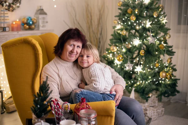 かわいい子供 母と祖母とクリスマスのための装飾された部屋に黄色のアームチェアに座って — ストック写真