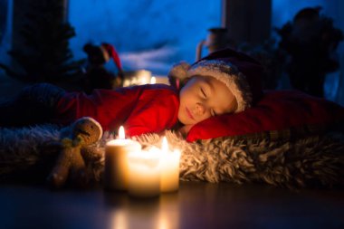 Güzel çocuk, evlat, Noel arifesinde pencerenin önünde Noel Baba 'yı merakla bekliyor.