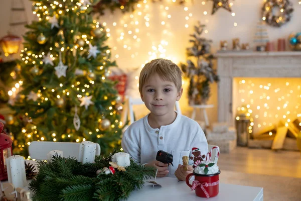 かわいい就学前の子供 ブロンドの男の子 家で装飾されたクリスマスルームで自宅で出現花輪を作る — ストック写真