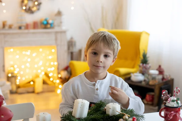 Nettes Vorschulkind Blonder Junge Bastelt Hause Geschmückten Weihnachtszimmer Einen Adventskranz — Stockfoto