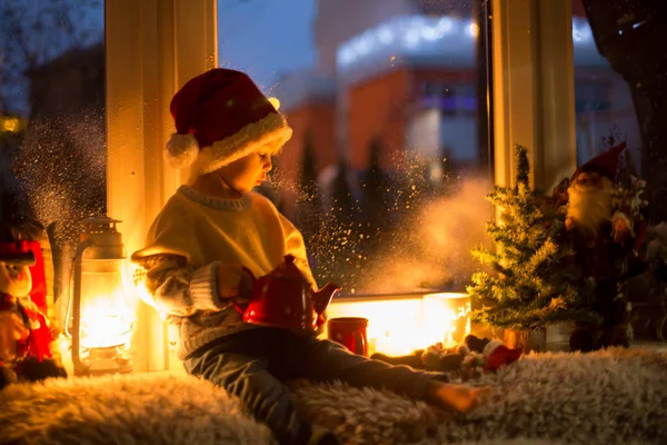 可爱的孩子 坐在窗上 在外面寻找圣诞老人 窗上的圣诞装饰 — 图库照片