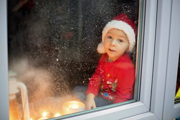 Wunderschönes Kleinkind Junge Wartet Heiligabend Fenster Und Sucht Neugierig Nach — Stockfoto