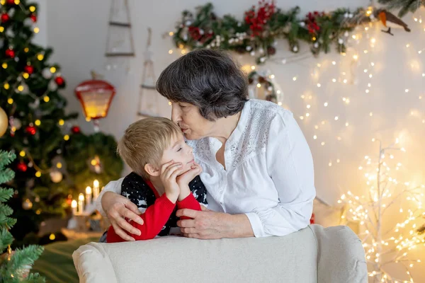 Christmas family picture in cozy home with lights and decoration, grandmother, mother and children