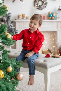 Mutlu şirin çocuk Noel 'de, tatilin tadını çıkarıyor, hediyeleri açıyor ve kurabiye yiyor.