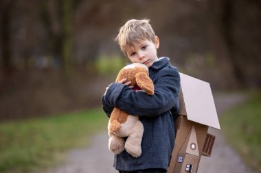 Little child, blond boy with pet dog, carying home on his back, kid, having paper house, emotional shot