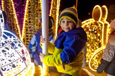 Cute child, boy, watching at lights in light show park, closeup