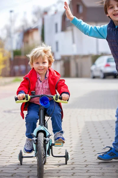 Małe Dziecko Blondyn Uczący Się Jeździć Rowerze Parku Pomocnymi Kołami — Zdjęcie stockowe