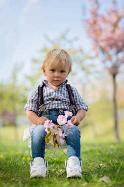Cute children in the park with grandmother, springtime