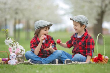 İki çocuk, erkek kardeşler, park, güzel bahar Çiçek Bahçe having oyunculuk ile Paskalya yumurtaları