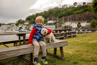 Child, visiting little town in south Norway, Arendal, on a rainy summer day, enjoying splendid views