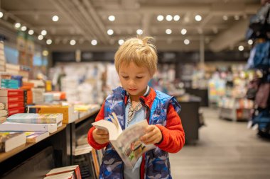 Child, visiting little town in south Norway, Arendal, on a rainy summer day, visiting bookstore