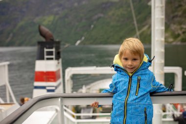 Family, kids and adults and a pet dog, enjoying trip to Geirangerfjord, amazing nature in Norway summertime