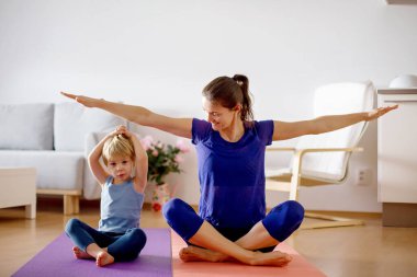 Anne ve çocuklar, koronavirüs sırasında evde egzersiz yaparken, insanlar evde jimnastik yaparken, spor merkezleri kapalıyken,