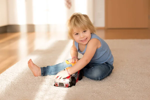 Schattig Blond Peuter Kind Spelen Met Grote Speelgoed Auto Thuis — Stockfoto