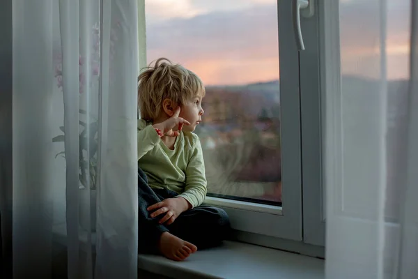 Sarışın Çocuk Gün Batımında Pencerede Oturuyor Dışarı Bakıyor — Stok fotoğraf