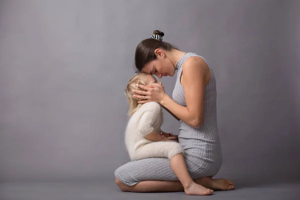 Jovem Mãe Abraçando Seu Lindo Menino Loiro Isolado Fundo Cinza — Fotografia de Stock