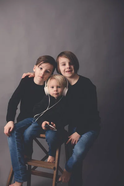 Édes Gyerekek Fiú Testvérek Fekete Pulóverben Zenét Hallgatni Elszigetelt Háttér — Stock Fotó