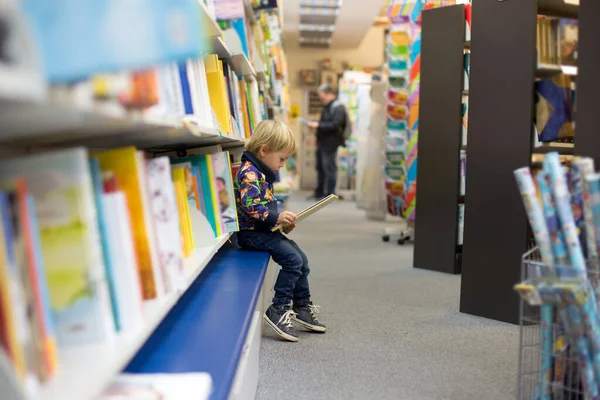 Bir Kitapçıda Oturup Kitap Okuyan Sevimli Küçük Bir Çocuk — Stok fotoğraf