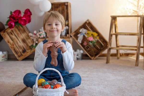 スタジオで甘い就学前の男の子 一緒に遊んで イースターの卵とチョコレートを食べて 自宅でイースター休暇の子供 — ストック写真