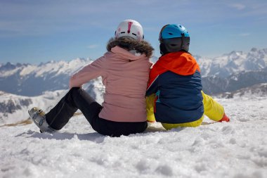 Mutlu aile, çocuklarla kayak tatili, açık havada güneşli güzel hava.