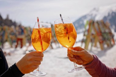 Mutlu aile, çocuklarla kayak tatili, güneşli güzel hava, güneşli bir günde aperol spreyi içen insanlar.