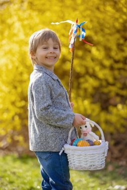 Cute preschool child, boy, holding handmade braided whip made from pussy willow, traditional symbol of Czech Easter used for whipping girls and women to receive eggs and sweets