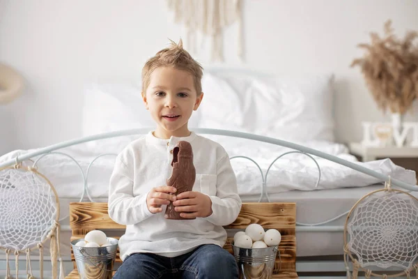 かわいいスタイリッシュな幼児の子供 白いシャツの少年 イースターの装飾で卵とチョコレートウサギと遊ぶ スタジオショット — ストック写真