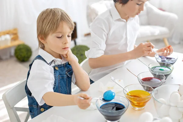 幸せな子供 カラフルな水で卵を着色するイースター自宅 日当たりの良い部屋 — ストック写真