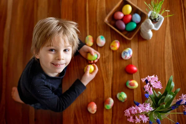 小金发碧眼的男孩儿在家里给复活节彩蛋上色 捷克共和国的传统是用树枝和鸡蛋 — 图库照片