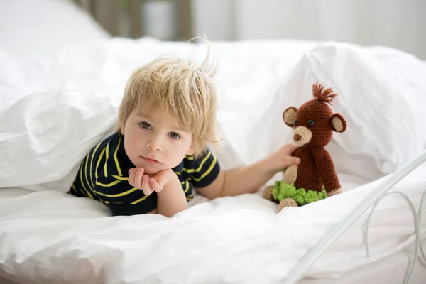 ブロンドの幼児の子供はベッドでぬいぐるみ猿と遊び 夏に遊ぶ — ストック写真