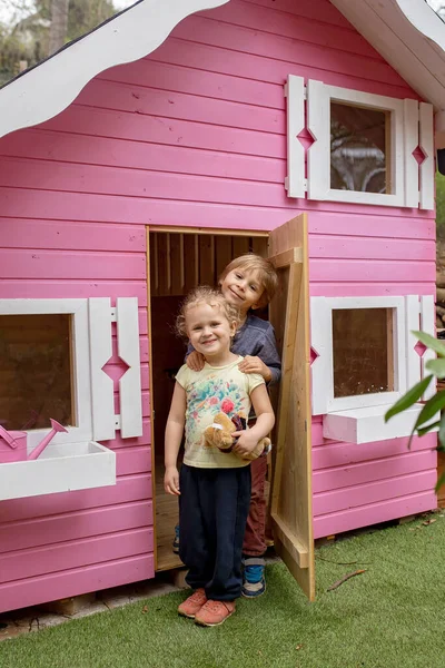 Dzieci Chłopiec Dziewczynka Bawiący Się Różowym Drewnianym Domu Dla Dzieci — Zdjęcie stockowe