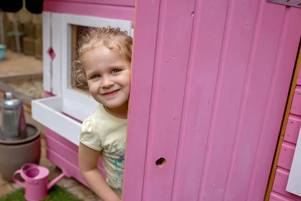 孩子们 男孩和女孩们 在后院里为孩子们在粉红色的木屋里玩耍 — 图库照片