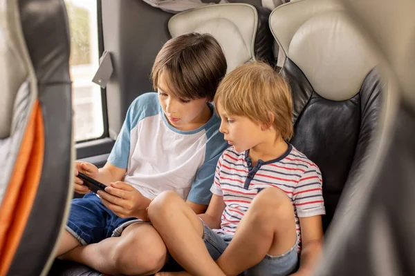 長距離旅行 家族旅行でバスで旅行中の子供 携帯電話で遊ぶ家族の休暇 — ストック写真