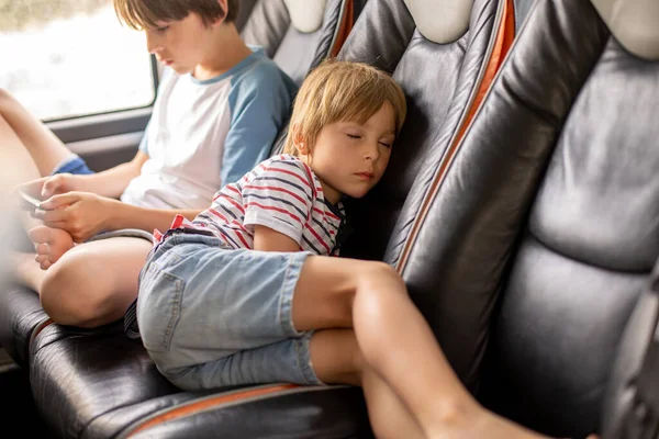 可爱的金发男孩 度假回来的路上睡在公共汽车上 哥哥在电话里玩 家里放假 — 图库照片