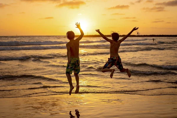 快乐的少年小伙子们 日落时在海滩上跑来跑去 嬉戏玩耍 泼洒水 跳到沙滩上 以色列特拉维夫 — 图库照片